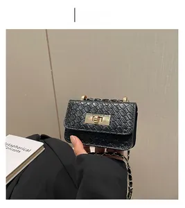 Close-up of black woven texture handbag with golden metal lock and chain strap detail