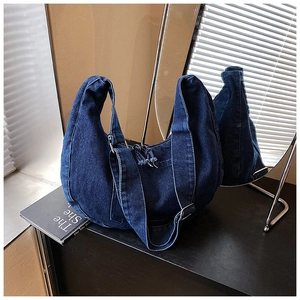 Vue détaillée du sac hobo en denim bleu foncé avec une large bandoulière réglable