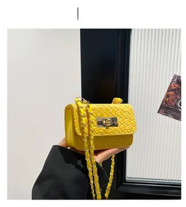 Detail of yellow woven texture on a flap bag with a golden rectangular twist lock