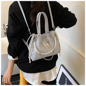 Detail of light blue drawstring backpack with metal butterfly and pearl chain strap