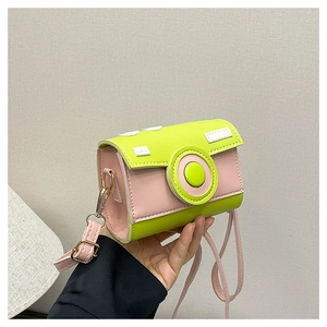 Close-up of pink and green camera-shaped mini crossbody bag with stitched leather detail