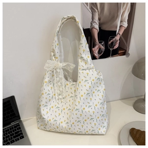 Detail of floral canvas tote bag with a white lace bow and elegant vintage pattern
