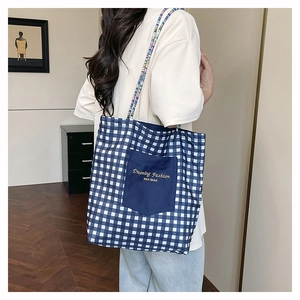 Détail du cabas en toile à carreaux bleus avec broderie et poignées en corde tressée