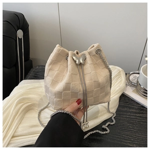 Detail of woven bucket bag with silver chain drawstring and butterfly metal buckle