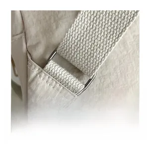 Detail of silver rectangular metal hardware and reinforced stitching on nylon bag