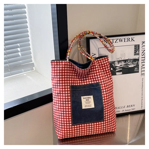 Detail of red checkered canvas tote with denim pocket and colorful braided rope handles