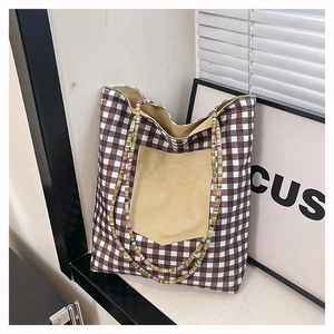 Gros plan du sac en toile à carreaux marron avec une poignée en perles colorées