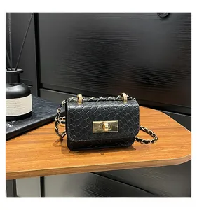 Close-up of black woven texture leather bag with elegant gold clasp and chain strap