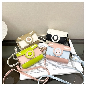 Detail view of four camera-shaped mini crossbody bags in various pastel color combinations
