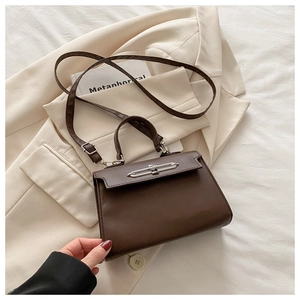 Detailed view of dark brown leather crossbody bag with silver metallic twist lock closure