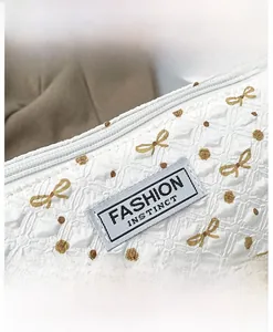 Détail de la texture bulle blanche avec broderie papillon et poignée en perles