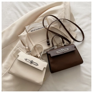 Detail view of retro square crossbody bags in beige and brown with metal bar locks