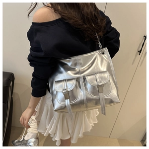 Detail of silver metallic tote bag featuring double pockets and adjustable metal buckles