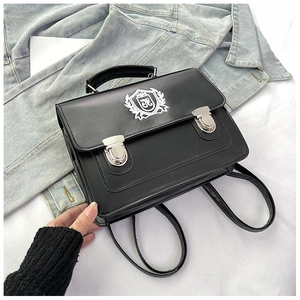 Détail d'un sac à dos style JK en similicuir noir avec écusson blanc brodé dessus