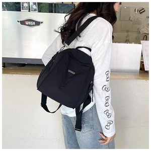 Detail of black nylon backpack side pocket and adjustable strap in lifestyle setting
