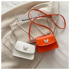 Detail of trendy mini crossbody bags featuring butterfly metal buckle in white and orange