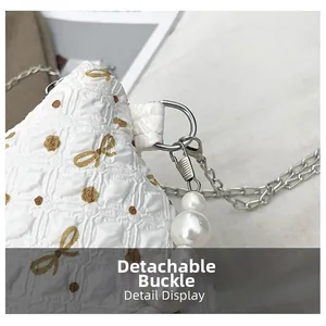 Détail du sac gaufré blanc avec motif papillon doré et breloque en perles amovible