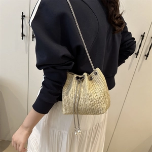 Japanese style woven straw bucket bag with drawstring closure and silver chain strap