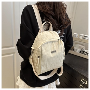 Close-up of lightweight pleated nylon backpack in beige with adjustable straps