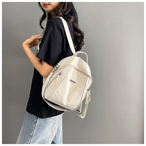 White nylon backpack shown on model highlighting its lightweight and casual design