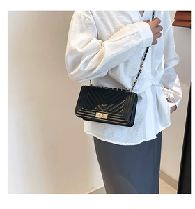 Détail du sac bandoulière noir matelassé avec surpiqûres en V et boucle dorée