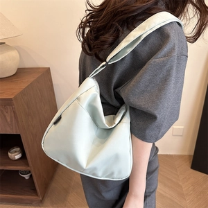 Minimalist light green nylon shoulder bag with adjustable wide strap and metal zipper