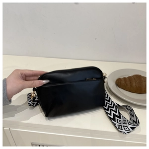 Détail du sac bandoulière noir demi-lune avec sangle géométrique et finitions dorées