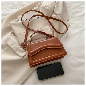 Close-up of caramel leather crossbody bag with wave quilting and adjustable strap