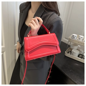 Detail of red small square bag showing wavy quilted lines and golden metal hardware