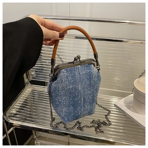Détail d'un sac à main en denim bleu à pois blancs avec poignée en cuir et bandoulière