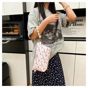 Trousse à maquillage rose avec motifs nœuds rouges et poignée en perles décorative