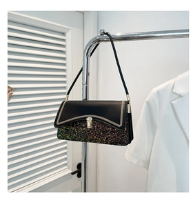 Detail of sequined shoulder bag showing zigzag woven metallic trim and glittery finish