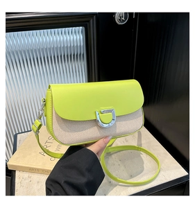 Dettaglio della borsa a tracolla in pelle verde neon e tessuto con fibbia a D argento