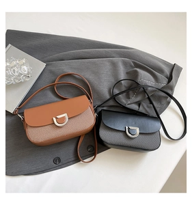 Dettaglio della borsa chic con patta e chiusura a D in metallo vintage e texture miste