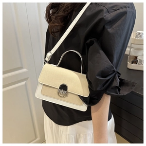 Close-up of beige straw texture and white leather flap with silver metal buckle detail