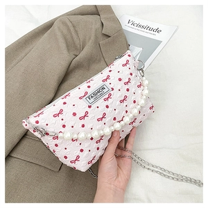 Détail du sac rose imprimé papillons avec poignée en perles et bandoulière chaîne