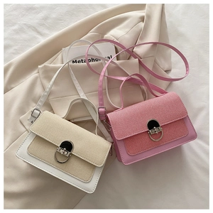 Detail view of woven leather texture and silver circular buckle on crossbody bags