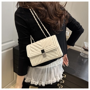 Back view of a white quilted crossbody bag with V-shaped stitching and chain strap