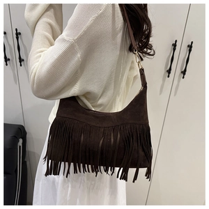 Detail of bohemian dark brown suede shoulder bag featuring long fringe and gold metal hooks