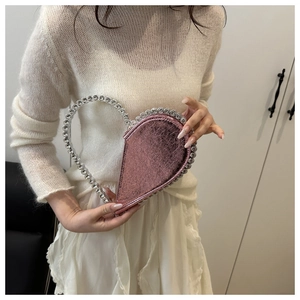 Detail of pink metallic heart-shaped handbag with large sparkling rhinestone-encrusted handle