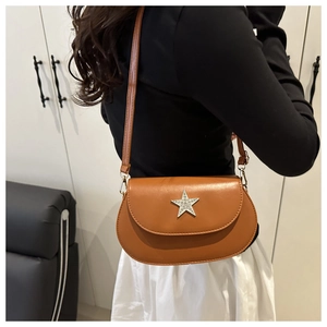 Brown leather saddle bag with star rhinestone buckle shown on person side view