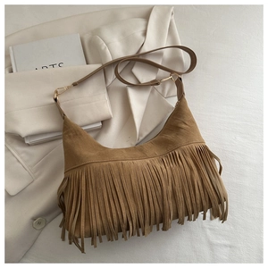 Close-up of brown suede bohemian tote bag with long fringe and gold hardware details
