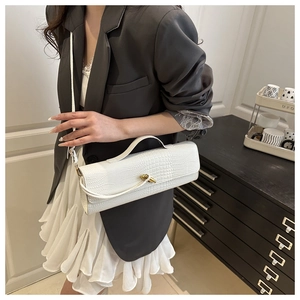 Detail of white crocodile pattern baguette bag with a unique gold knot metal buckle