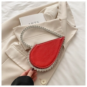 Macro shot of red heart evening clutch with large sparkling rhinestones on blazer