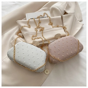 Detail of pink and silver evening bags with crystal buckles on beige suit