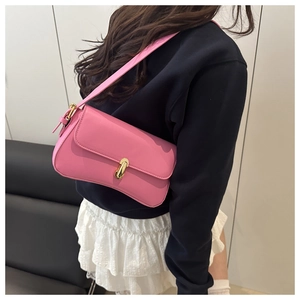 Detail of pink faux leather shoulder bag with gold metal buckle and adjustable strap