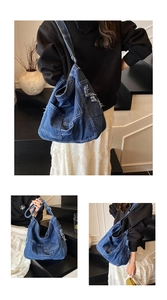 Detail of large denim shoulder bag with multiple functional pockets and frayed edges