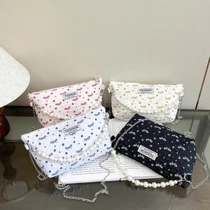 Trousse à maquillage matelassée à nœuds avec poignée en perles et bandoulière chaîne