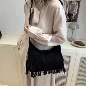 Bohemian black tassel shoulder bag with crescent shape in minimalist matte leather finish