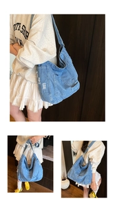 Detailed view of light blue denim tote bag with washed texture and fringe edges